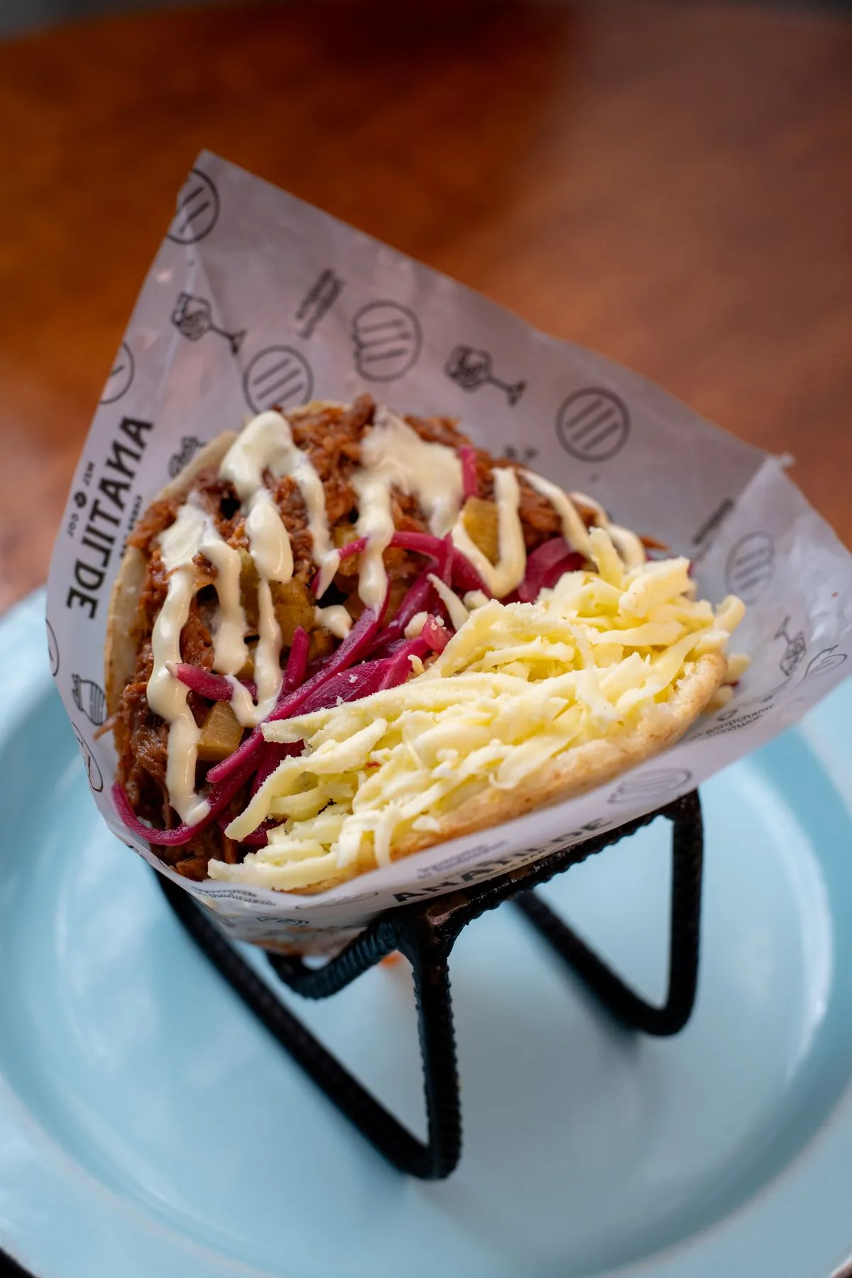 Arepa de pulled pork, servida en el empaque de la casa